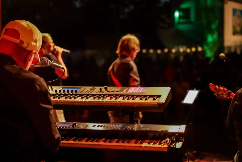 Band bei Nacht auf der Open-Air-Bühne, Keyboard im Vordergrund