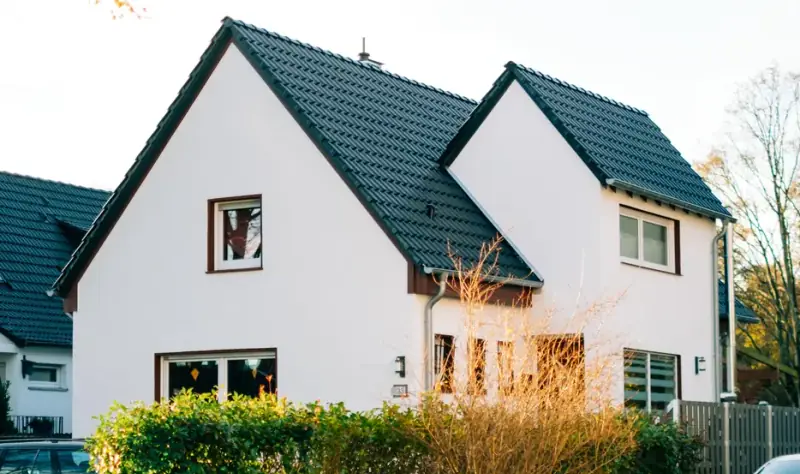 Freistehendes Einfamilienhaus mit weißer Fassade, Straßenansicht für Exposé und Vermarktung